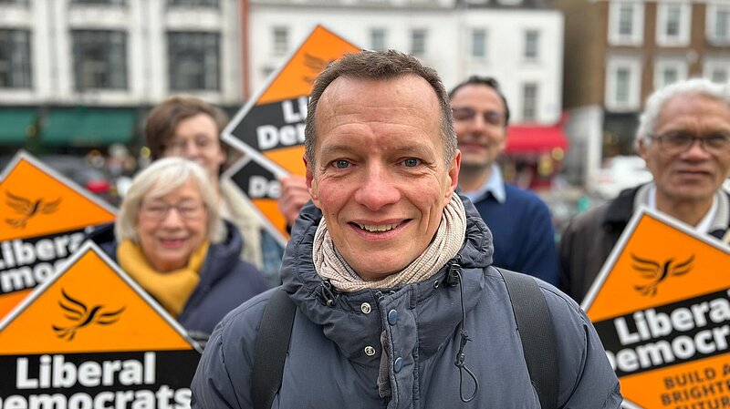 Christophe with Lib Dem supporters and diamonds behind him
