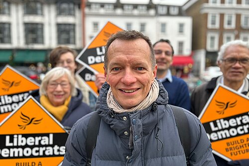 Christophe with Lib Dem supporters and diamonds behind him